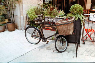 店先に置かれた大きな籐かご付き三輪自転車をKODACOLOR 100 35mmフィルムで撮影した写真