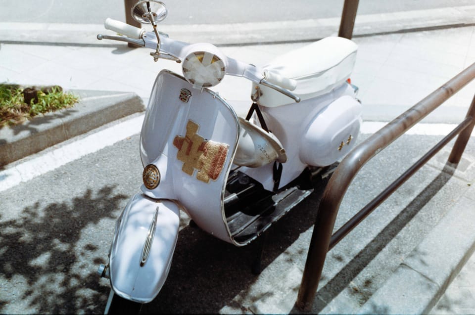 街角に停められた淡いブルーのスクーターをKODACOLOR 100 35mmフィルムで撮影した写真